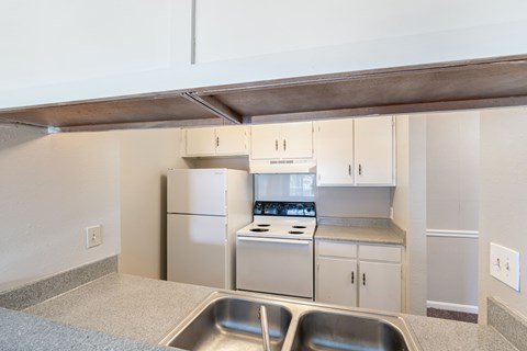 A kitchen with a stove top oven and a sink.