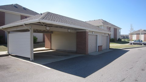A garage with a brick wall and a white door is labeled with the number 5.