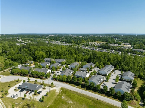 A bird's eye view of a residential area with houses and a community center.