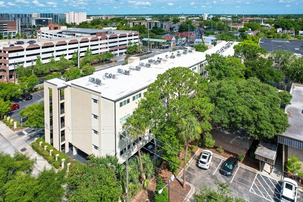 an aerial view of a building with cars parked in a parking lot