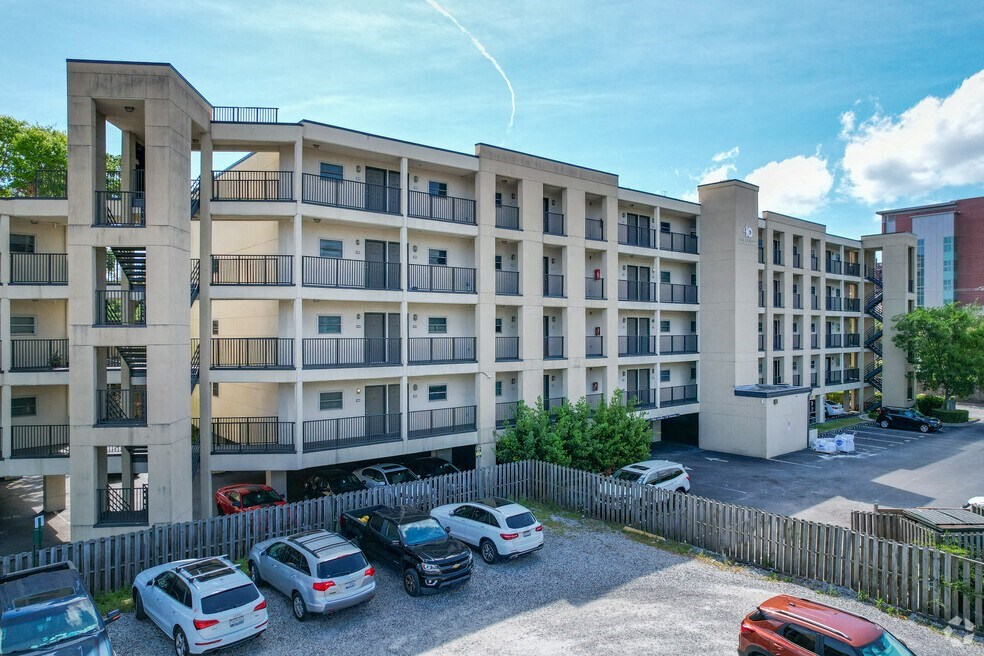 an image of an apartment building with cars parked in front