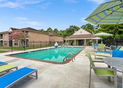 A pool with a slide and a table with chairs.
