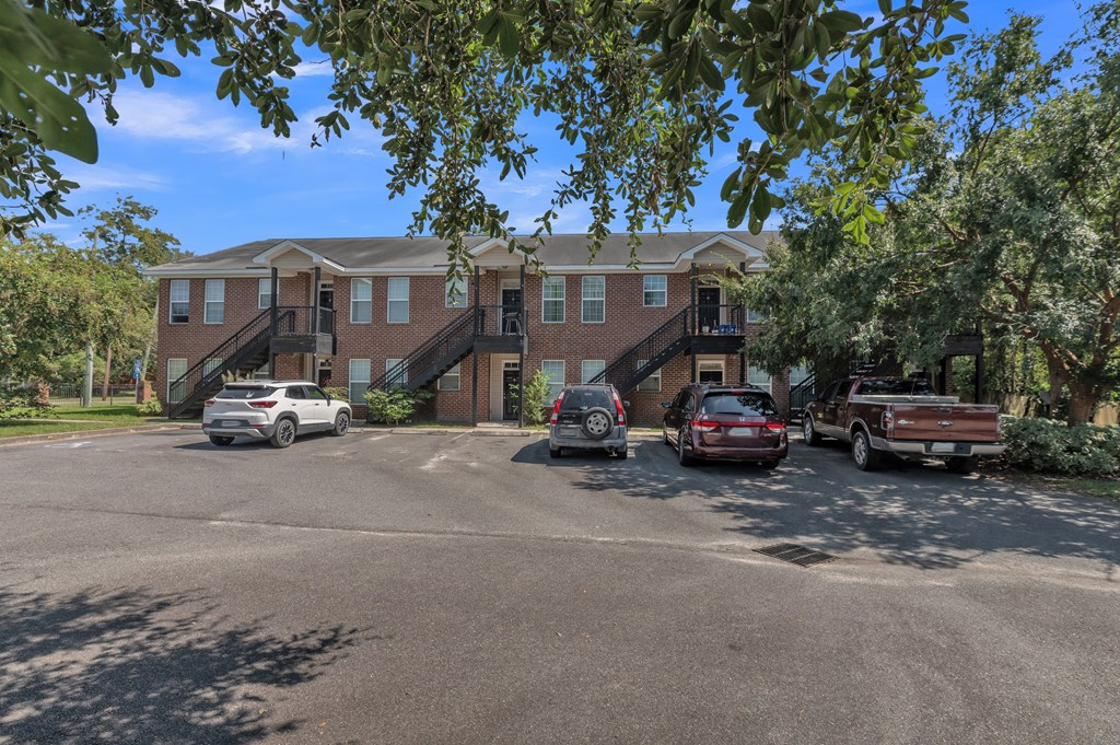 a large apartment building with cars parked in front of it