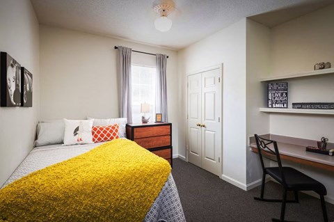 a bedroom with a bed and a desk in a 555 waverly unit