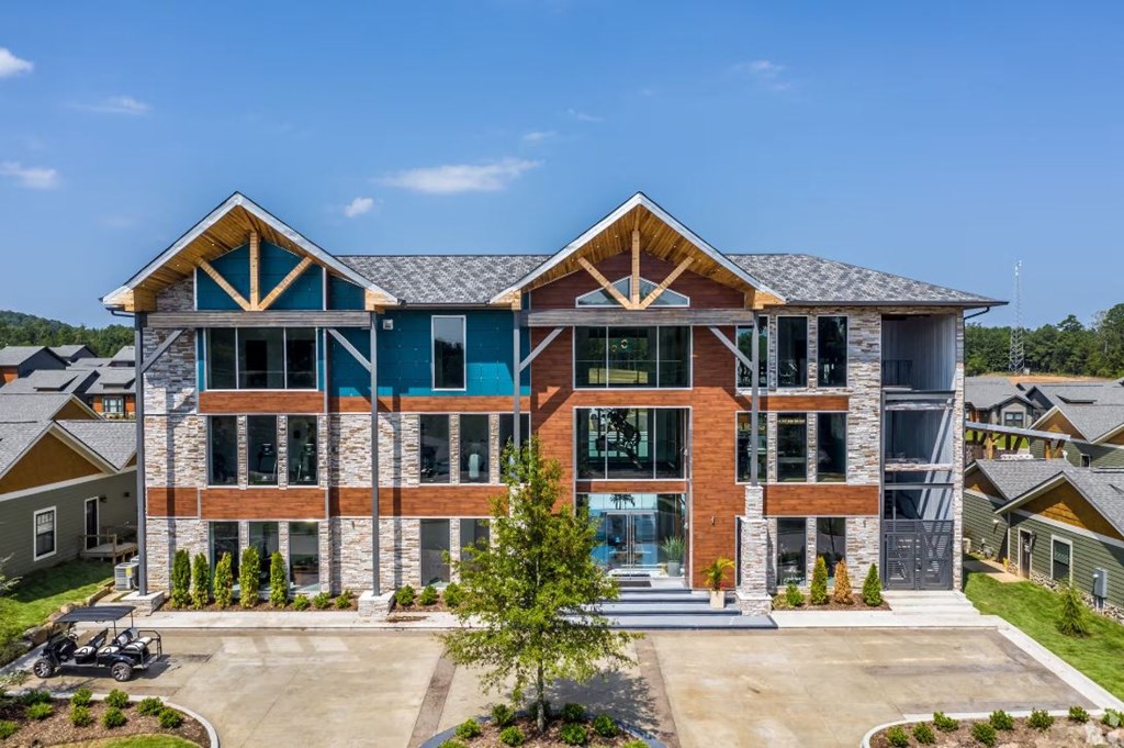 a large brick building with a gray roof and blue shutters