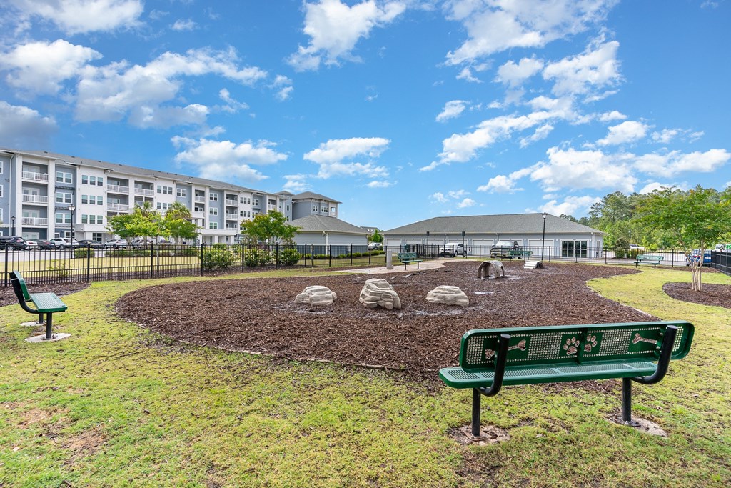 a park with a bench and a grassy area in front of a building
