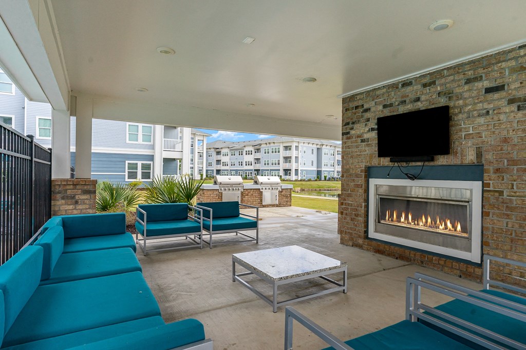 a fireplace and lounge area on the patio of a building