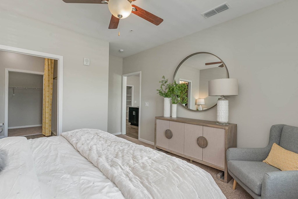 a bedroom with a ceiling fan and a mirror