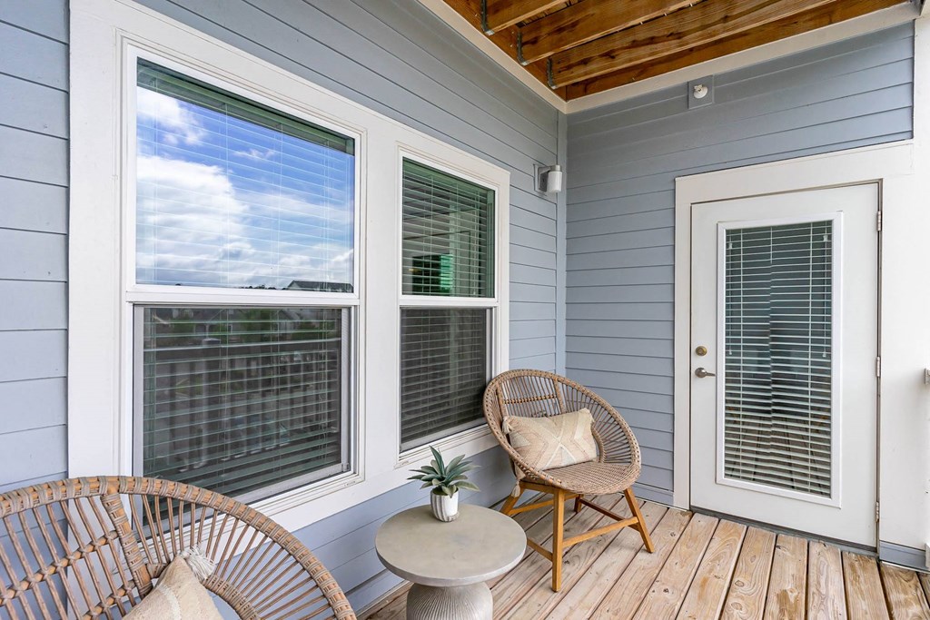 a porch with two chairs and a table