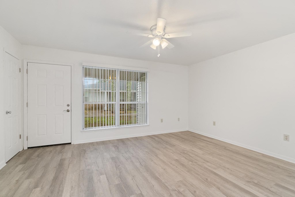 a bedroom with hardwood floors and white walls