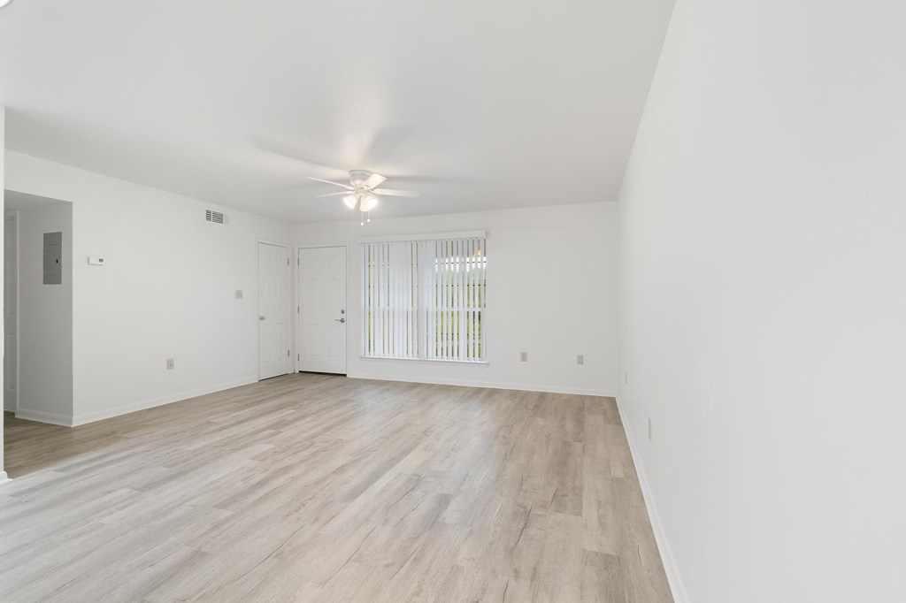 a bedroom with hardwood floors and white walls