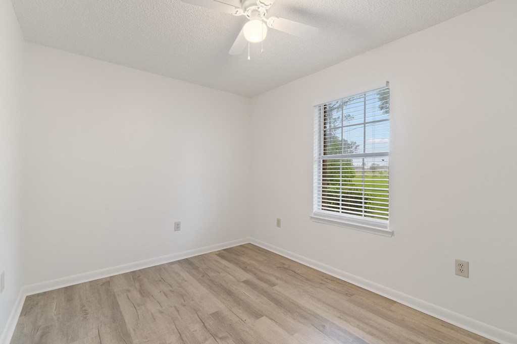 a bedroom with hardwood floors and a ceiling fan