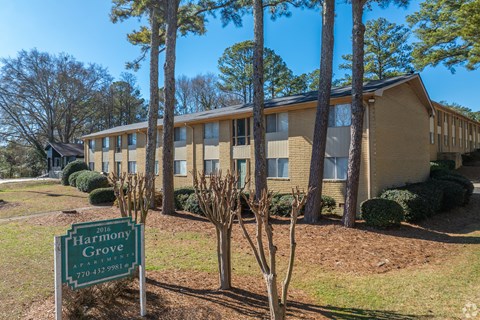 A sign for Harmony Grove is in front of a building.