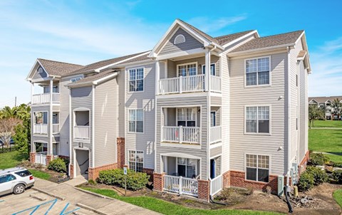 A large two-story apartment building with a parking lot in front.
