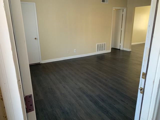 A room with a wooden floor and white walls.