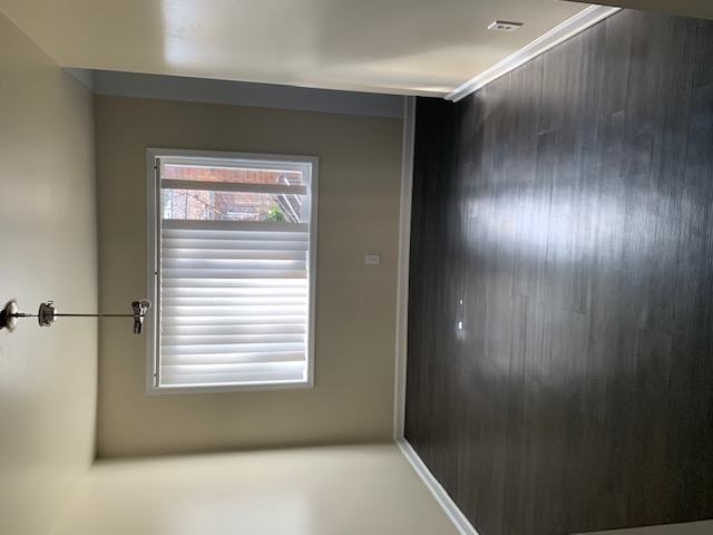 A room with a window and a wall on the right side.