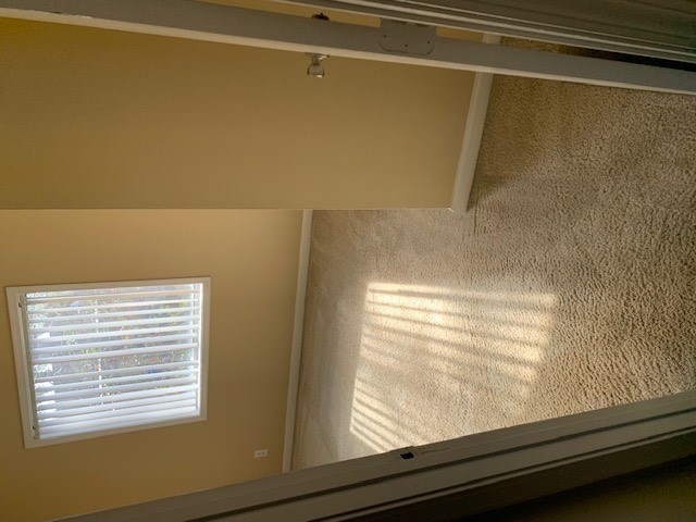 A window with white blinds is on the wall.