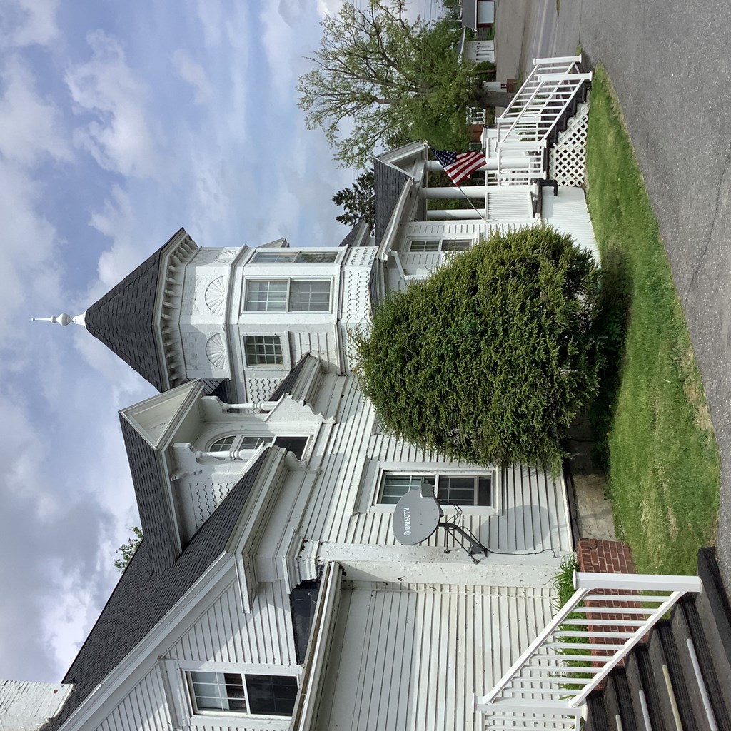 an aerial view of a white apartment building with stairs and a yard