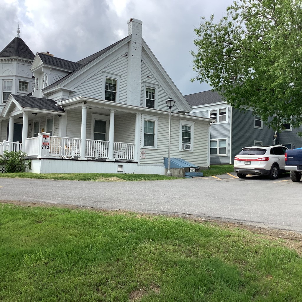 a white house with a white car parked in front of it