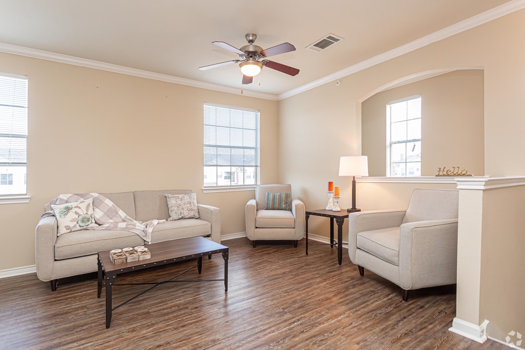 A living room with a couch, two chairs, and a coffee table.
