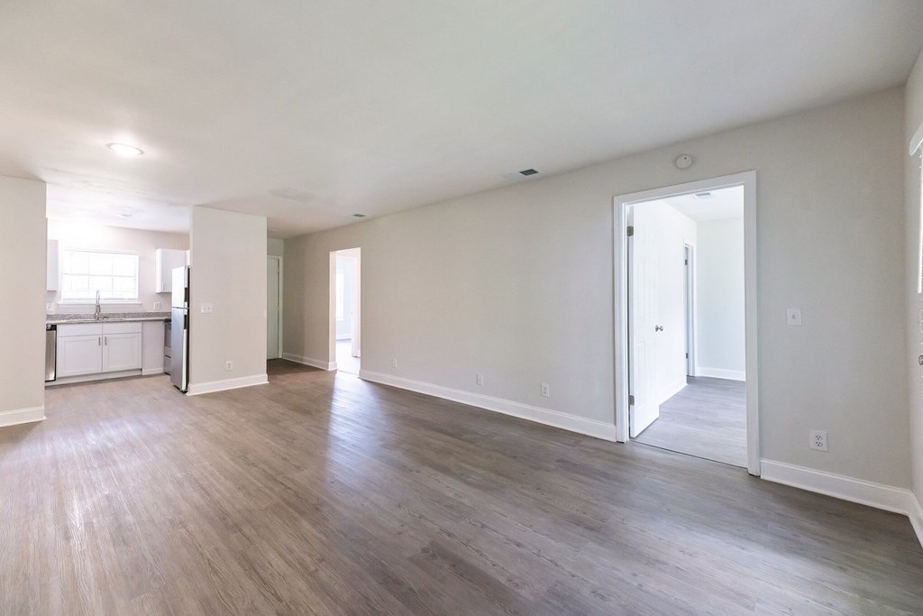 an empty living room with white walls and wood floors