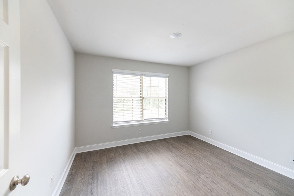 an empty room with white walls and a window