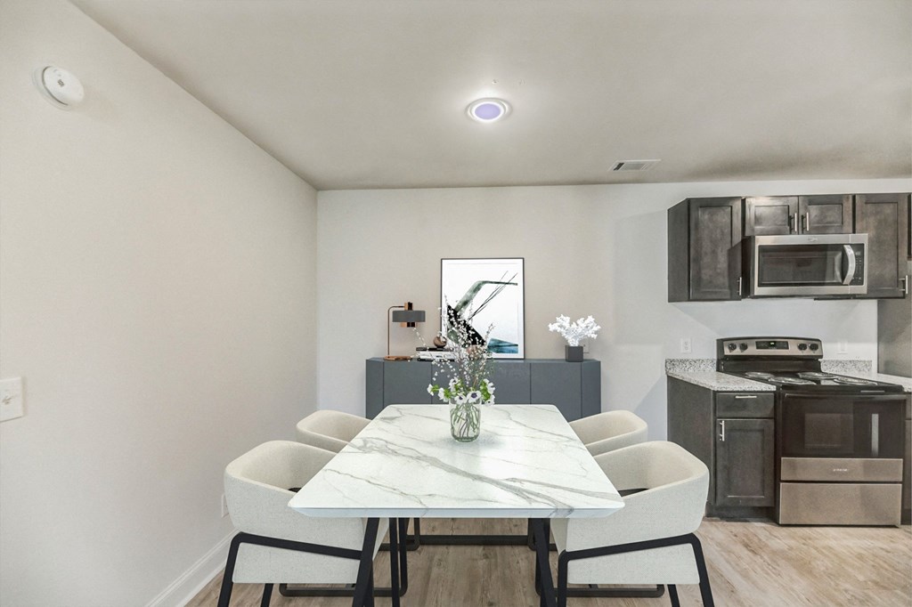 a kitchen and dining room with white chairs and a marble table