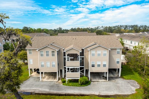 A large, two-story residential building with a driveway in front.
