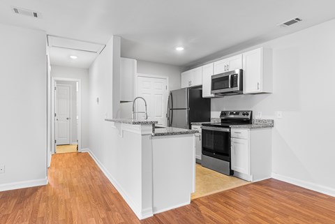 A kitchen with white cabinets and black appliances.