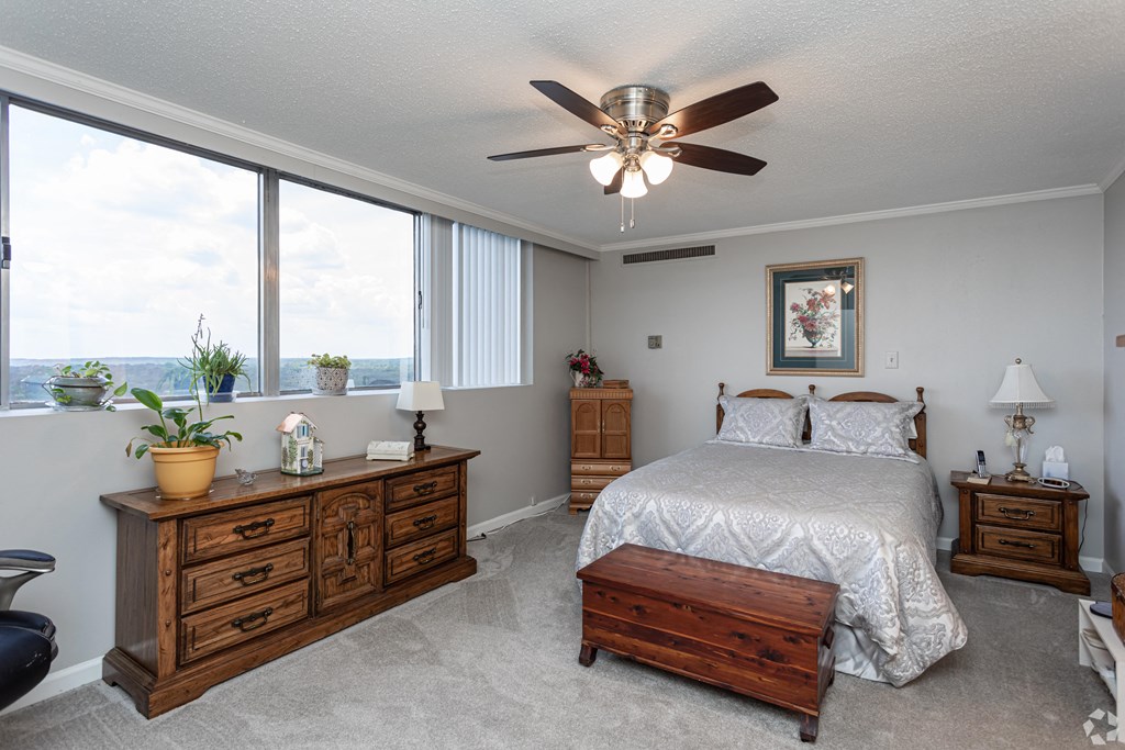 a bedroom with a large bed and a ceiling fan
