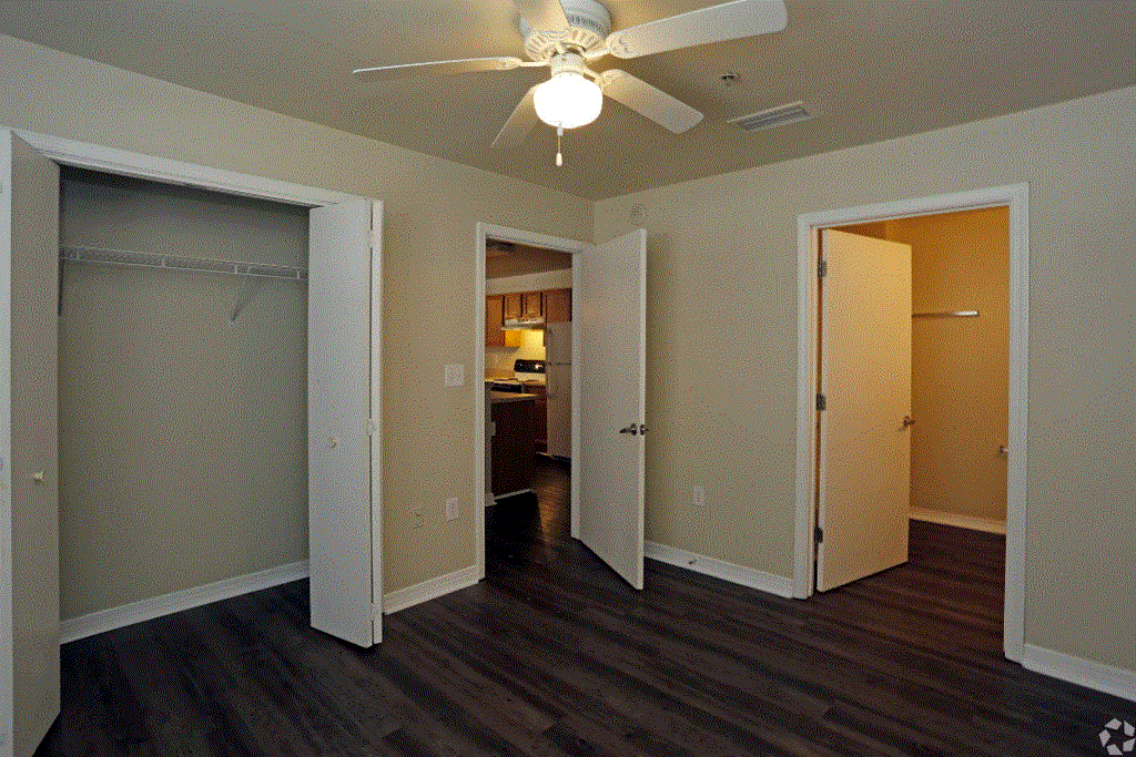 a bedroom with a ceiling fan and a closet with a door open