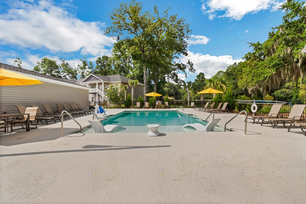 a pool with lounge chairs and umbrellas