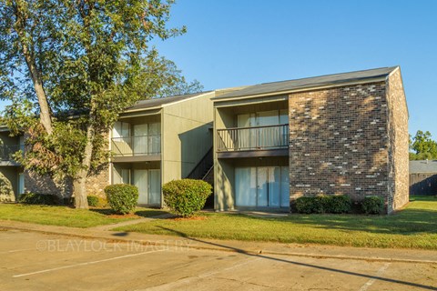 an apartment building with a parking lot in front of it