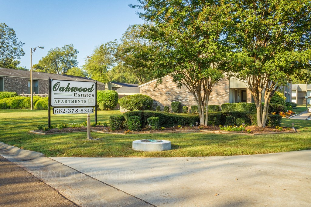 a sign in front of a house that reads oakwood estates apartments