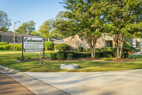 a sign in front of a house that reads oakwood estates apartments