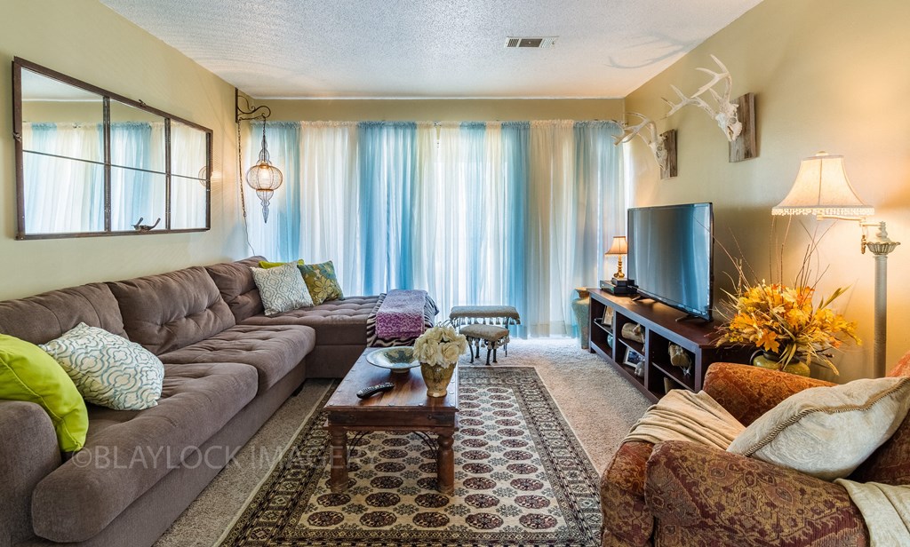 a living room with a large couch and a flat screen tv