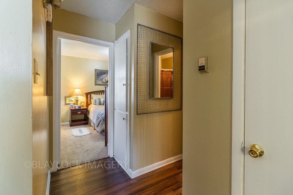 a bedroom with a bed and a nightstand with a lamp and a mirror on the wall