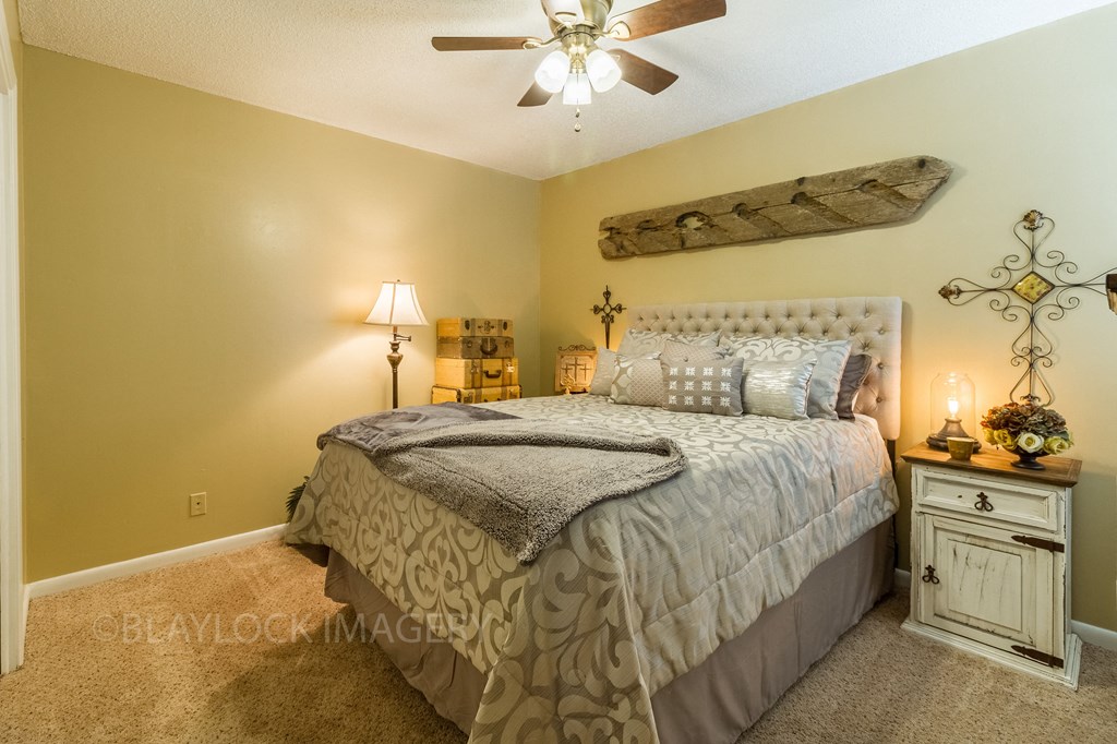 a bedroom with a bed and a ceiling fan
