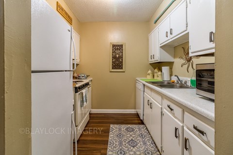 a kitchen with white cabinets and white appliances