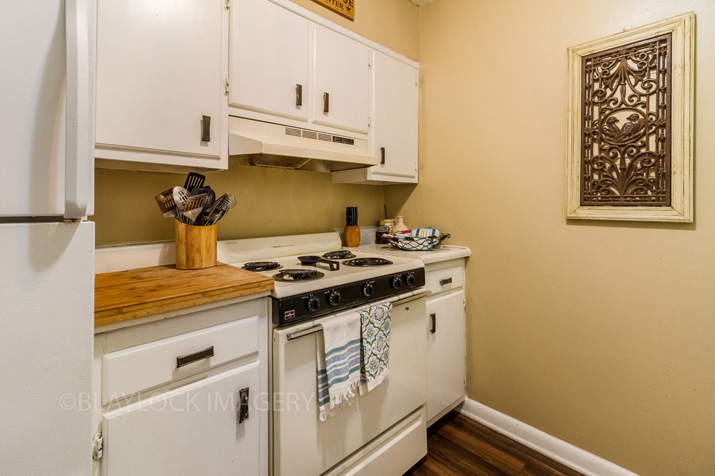 a kitchen with white cabinets and a stove top oven