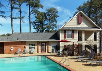 A house with a pool in front of it.