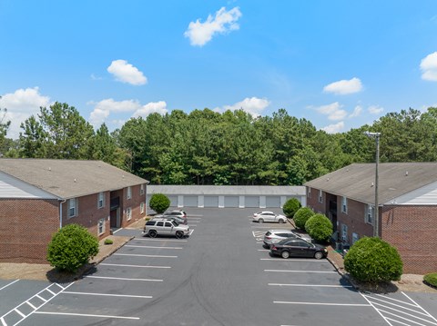 A parking lot with cars parked in it and trees in the background.
