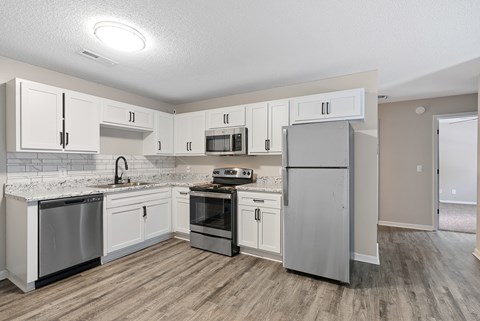 A kitchen with white cabinets and stainless steel appliances.