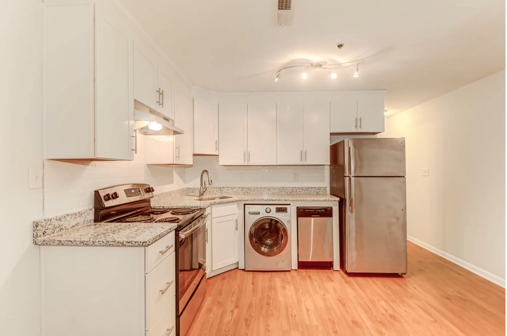 a kitchen with white cabinets and stainless steel appliances