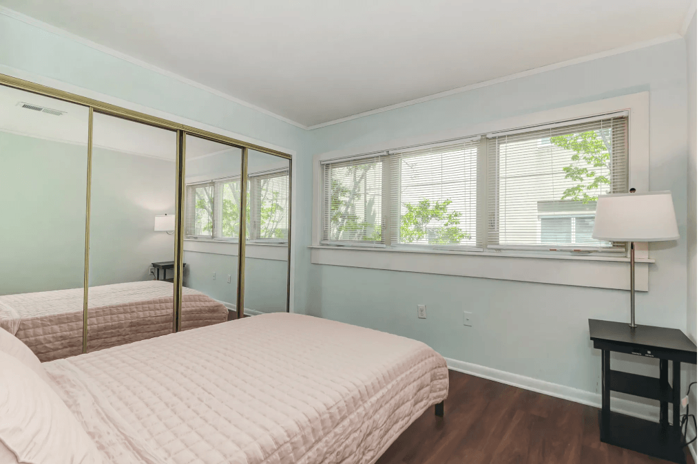 a bedroom with a bed and a large window