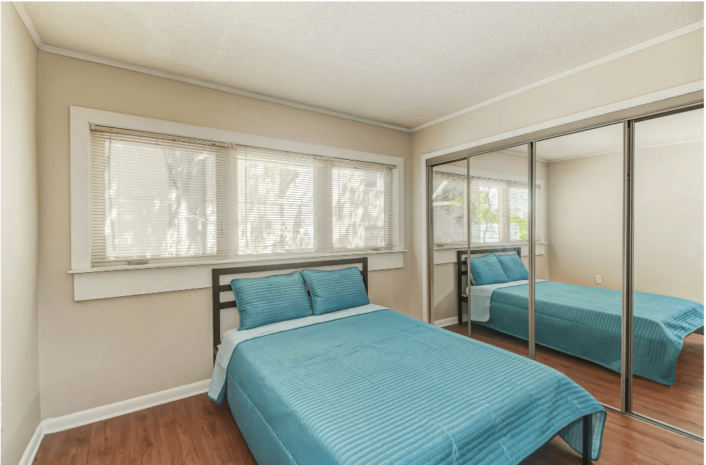 a bedroom with two beds and a mirrored closet