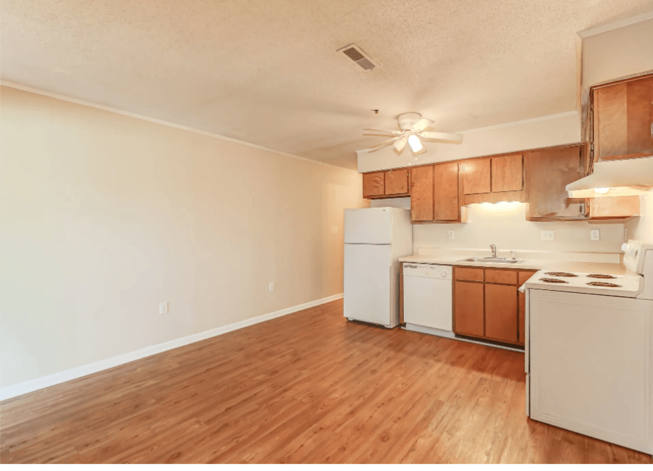 a spacious kitchen with white appliances and wood flooring