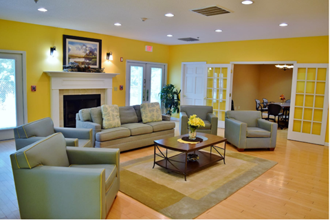 A living room with a fireplace and a painting on the wall.