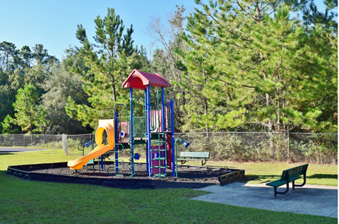 A playground with a red roof and a yellow slide.