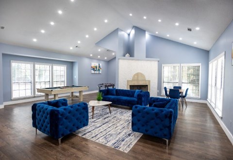 A living room with blue chairs and a fireplace.